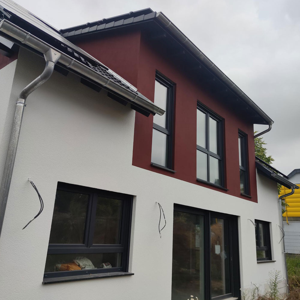 Modernes Wohnhaus mit kontrastreicher Fassade von Farbenfroh Raumgestaltung.