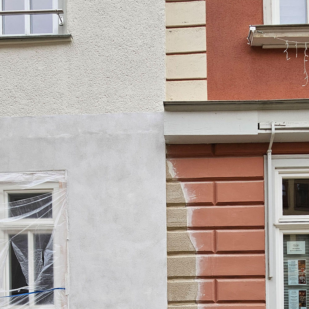 Helle Hausfassade mit Fenstern von Farbenfroh Raumgestaltung.
